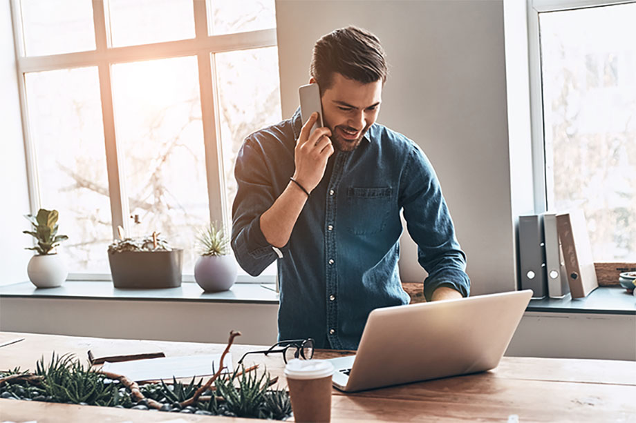 Young man working with laptop and phone